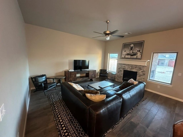 living room featuring dark hardwood / wood-style flooring, a fireplace, and ceiling fan