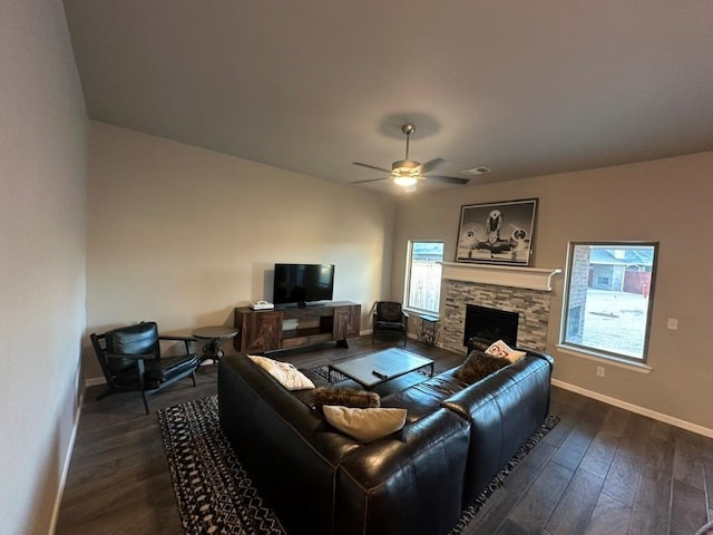 living room featuring dark hardwood / wood-style floors, ceiling fan, and a fireplace