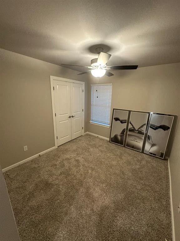 interior space with ceiling fan and carpet flooring