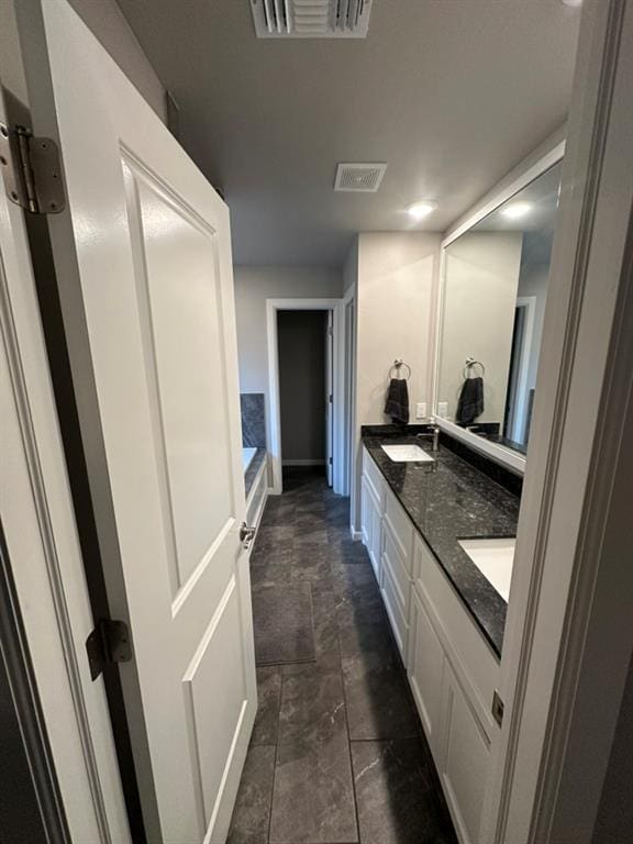 bathroom with vanity and a tub