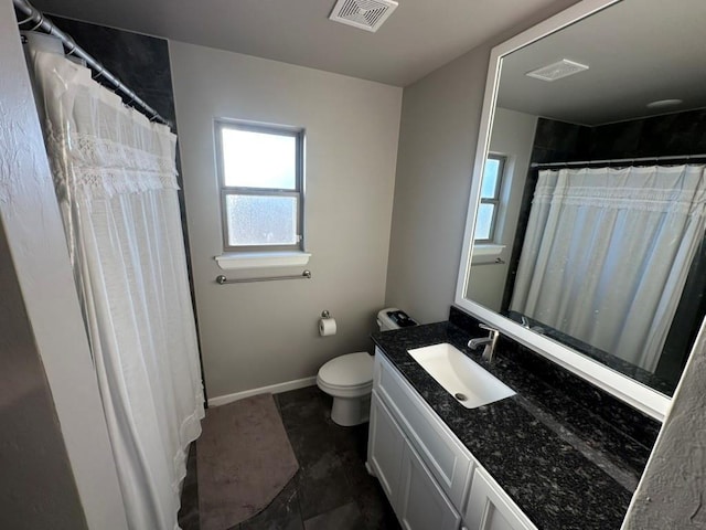 bathroom with vanity, toilet, and a healthy amount of sunlight