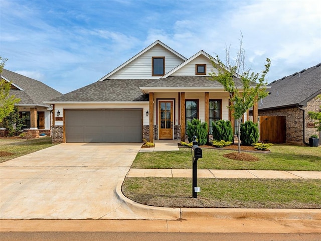 view of front of home with a garage, a porch, and a front yard