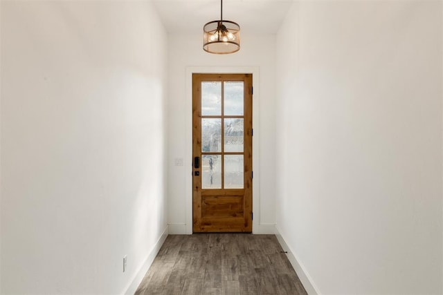 doorway to outside featuring a notable chandelier and wood-type flooring