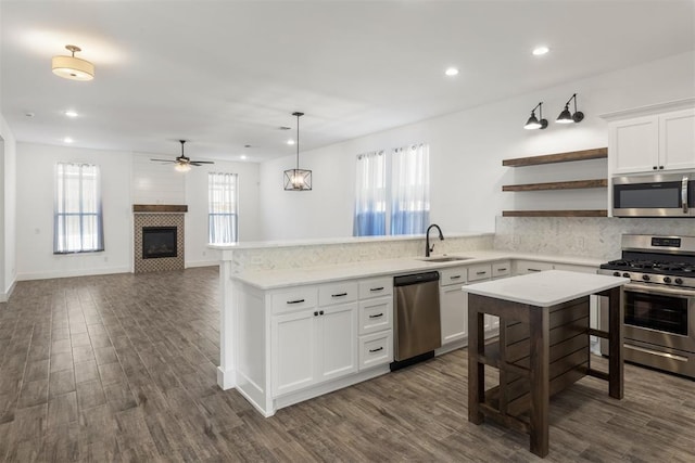 kitchen featuring pendant lighting, dark wood-type flooring, white cabinets, and appliances with stainless steel finishes