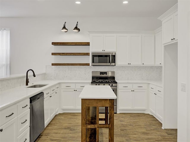 kitchen with white cabinetry, sink, light hardwood / wood-style flooring, and appliances with stainless steel finishes