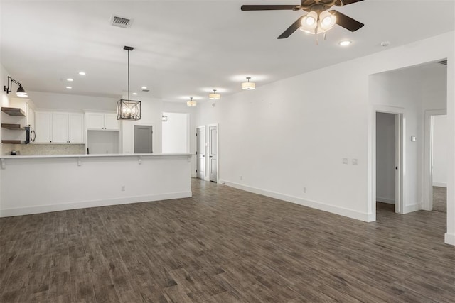 unfurnished living room with ceiling fan and dark hardwood / wood-style flooring