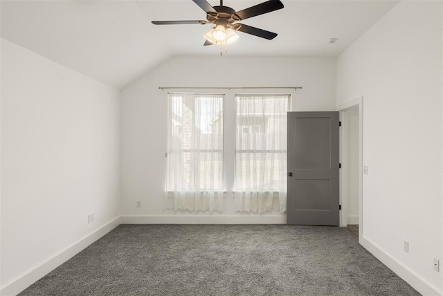 carpeted spare room featuring lofted ceiling and ceiling fan