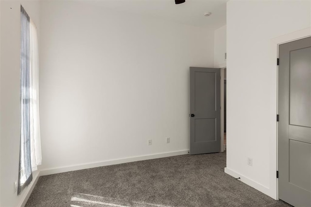 unfurnished room with dark carpet