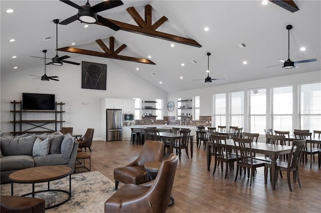 living room featuring wood-type flooring, high vaulted ceiling, ceiling fan, and beam ceiling