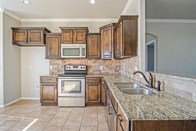 kitchen with sink, light stone counters, crown molding, tasteful backsplash, and stainless steel appliances