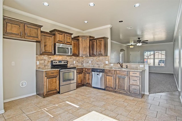 kitchen featuring crown molding, appliances with stainless steel finishes, sink, and backsplash