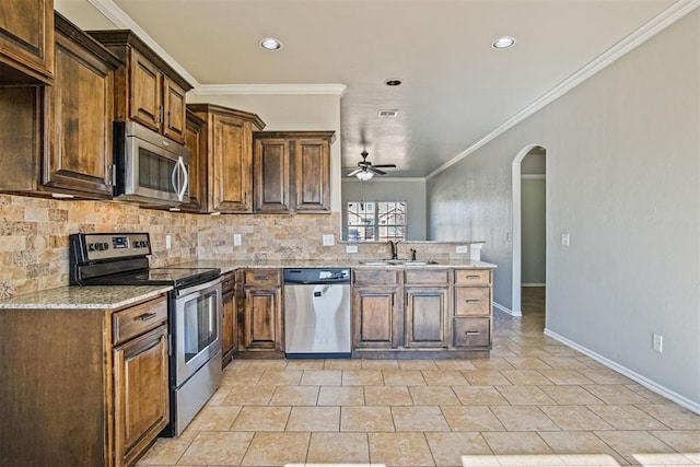 kitchen featuring sink, tasteful backsplash, ornamental molding, kitchen peninsula, and stainless steel appliances