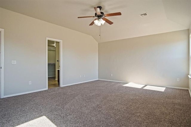 interior space with ceiling fan, lofted ceiling, and dark colored carpet