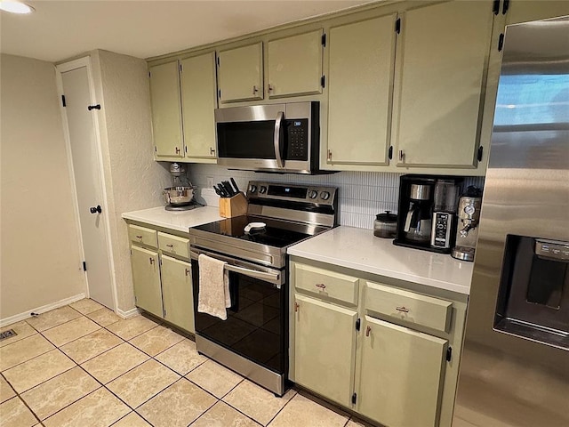 kitchen featuring light tile patterned flooring, appliances with stainless steel finishes, and backsplash