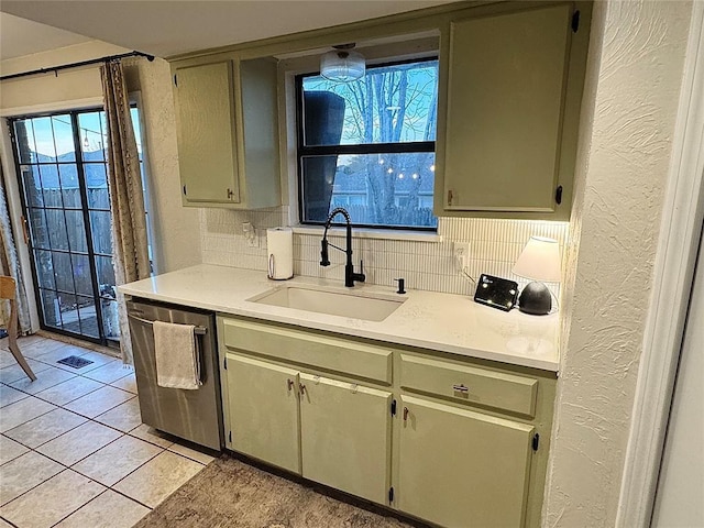 kitchen featuring tasteful backsplash, sink, light tile patterned floors, and dishwasher