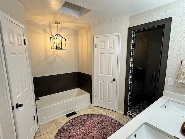 bathroom featuring tile patterned flooring, vanity, and a bath