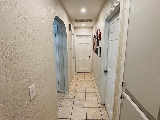 hall with light tile patterned floors