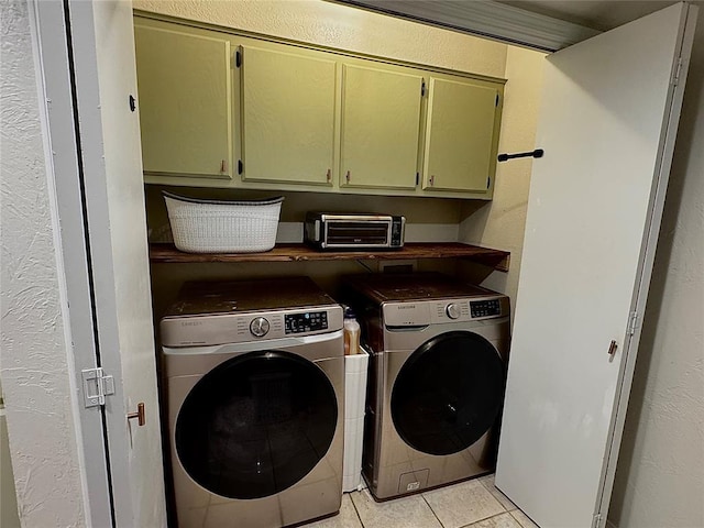 laundry area featuring cabinets, separate washer and dryer, and light tile patterned floors