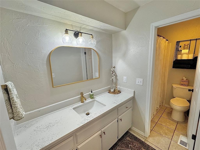 bathroom with vanity, tile patterned floors, and toilet