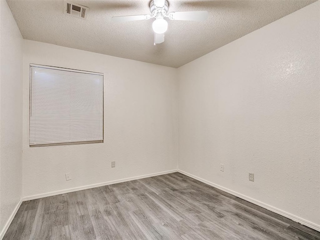 unfurnished room with ceiling fan, hardwood / wood-style floors, and a textured ceiling