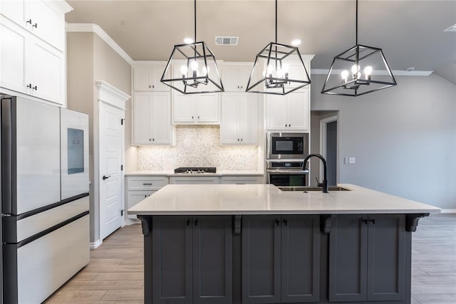 kitchen with fridge, white cabinets, a large island, and pendant lighting