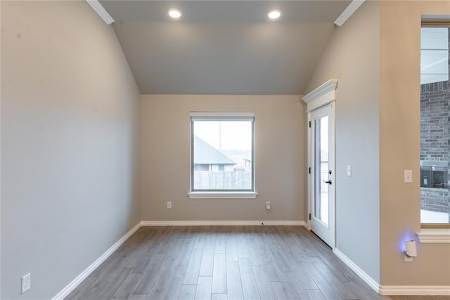 unfurnished room featuring lofted ceiling and wood-type flooring