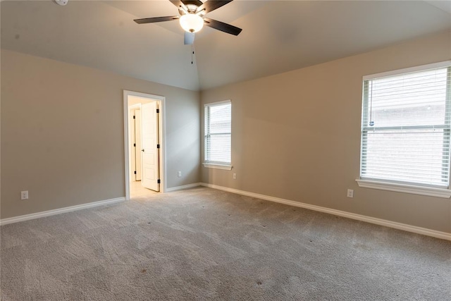 carpeted spare room with vaulted ceiling and ceiling fan