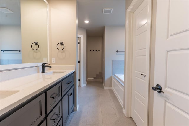 bathroom featuring vanity, a bath, and tile patterned flooring