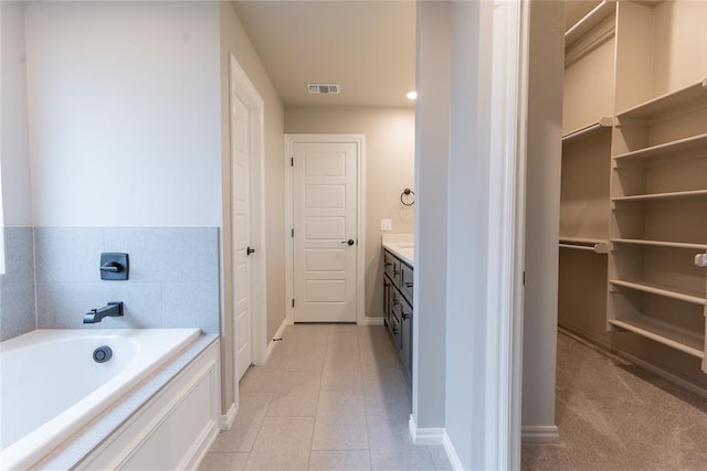 bathroom featuring vanity, tile patterned floors, and a bathtub