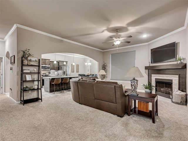 carpeted living room with crown molding and ceiling fan with notable chandelier