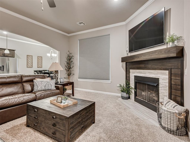 carpeted living room featuring crown molding, a fireplace, and ceiling fan with notable chandelier