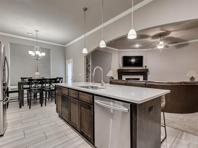 kitchen featuring stainless steel appliances, sink, a kitchen island with sink, and hanging light fixtures