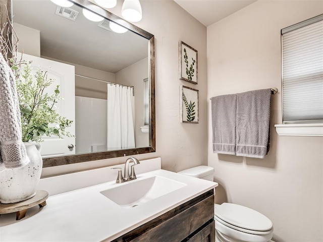 bathroom featuring vanity, toilet, and curtained shower