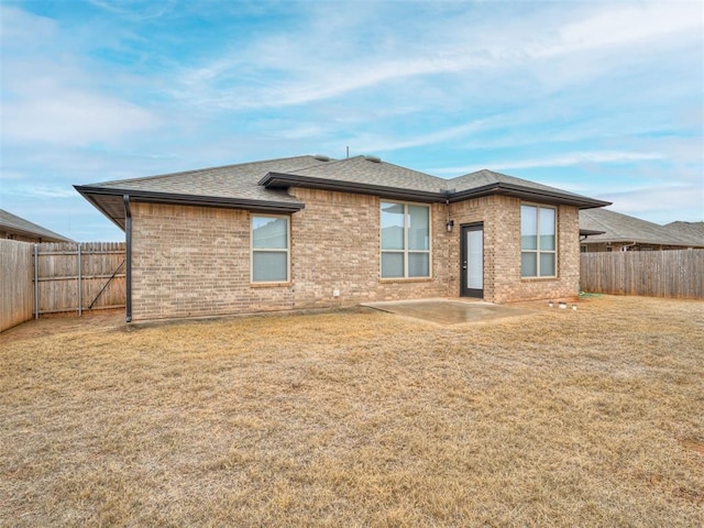 rear view of house with a yard and a patio area