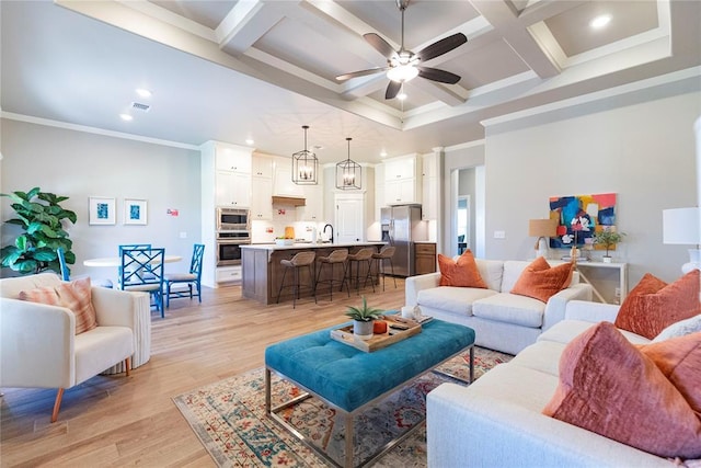 living room featuring crown molding, ceiling fan, beam ceiling, coffered ceiling, and light wood-type flooring