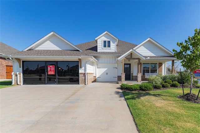 view of front facade with a garage, a front lawn, and covered porch