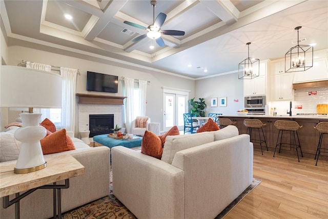 living room with coffered ceiling, light hardwood / wood-style floors, beam ceiling, and a wealth of natural light