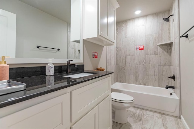 full bathroom with tiled shower / bath, vanity, and toilet