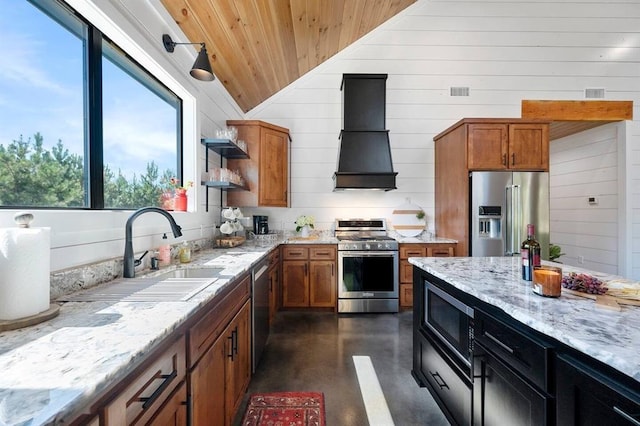 kitchen with vaulted ceiling, premium range hood, appliances with stainless steel finishes, sink, and light stone counters