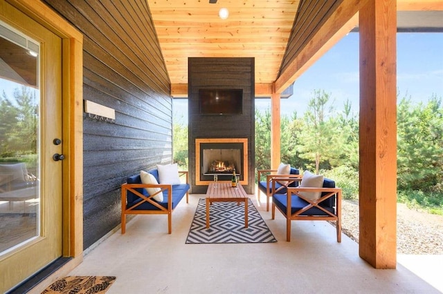 view of patio with an outdoor living space with a fireplace