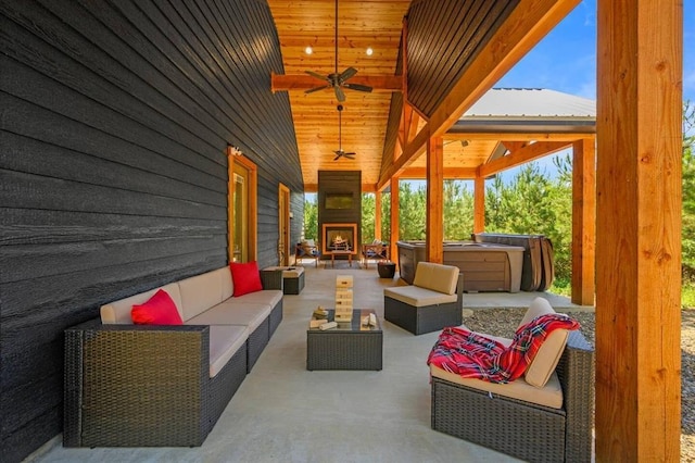 view of patio featuring ceiling fan, an outdoor living space with a fireplace, and a jacuzzi