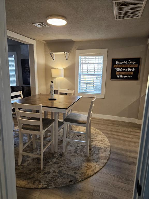 dining room featuring hardwood / wood-style floors and a textured ceiling