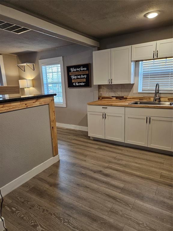 kitchen featuring white cabinetry, sink, dark wood-type flooring, and a textured ceiling