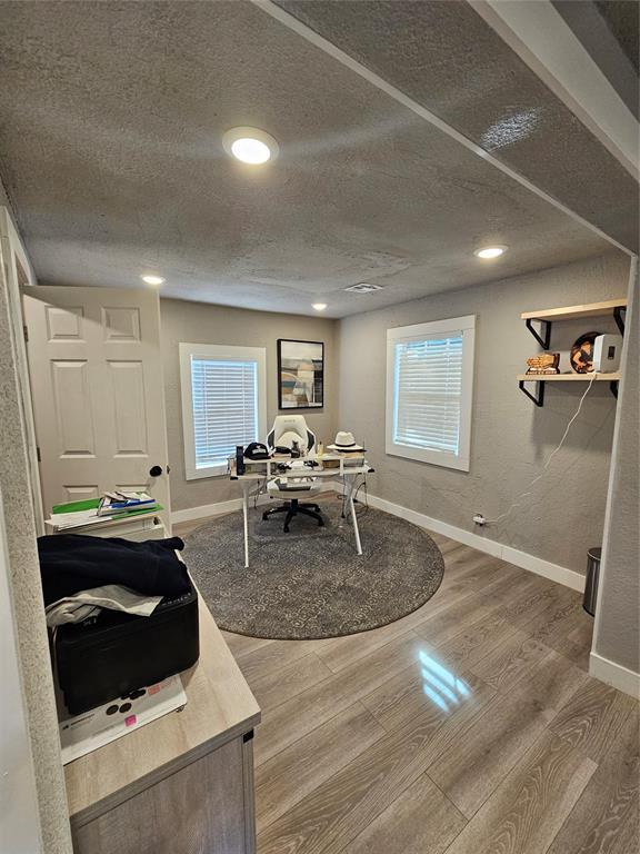 office area featuring wood-type flooring and a textured ceiling