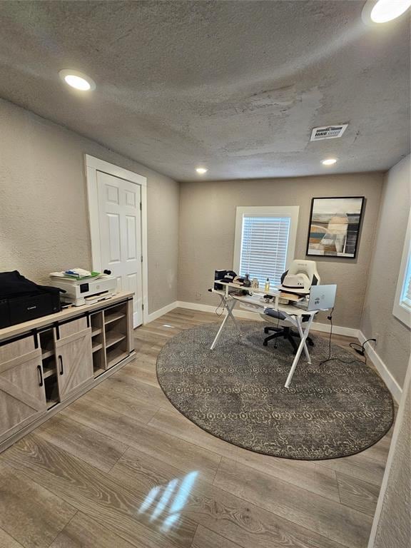 office area with hardwood / wood-style floors and a textured ceiling