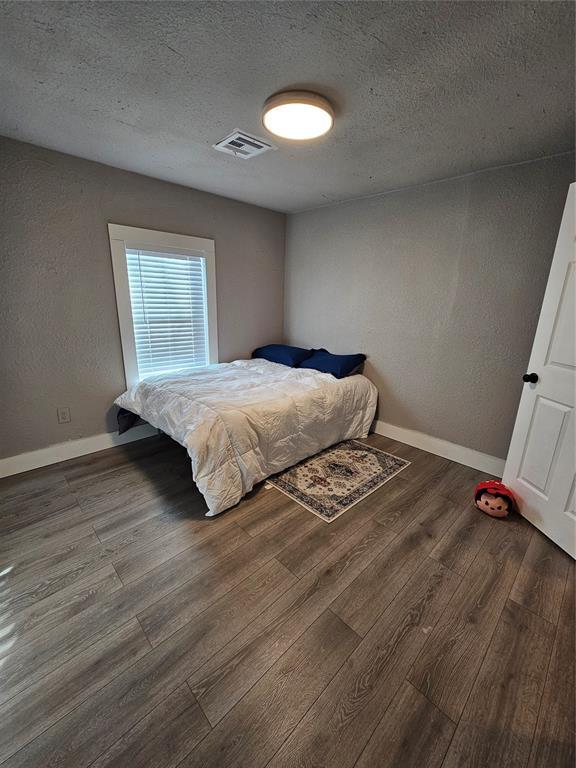 bedroom featuring hardwood / wood-style flooring and a textured ceiling