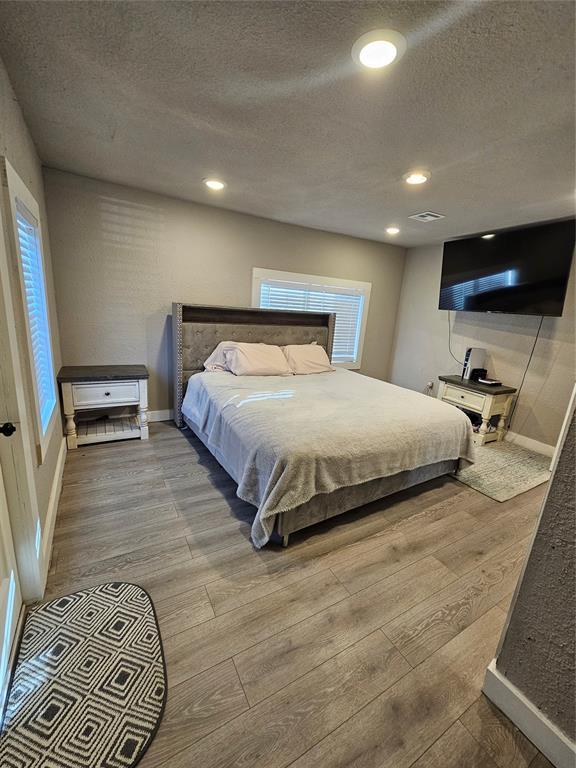 bedroom with hardwood / wood-style flooring and a textured ceiling