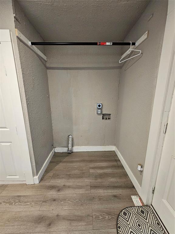 clothes washing area with hardwood / wood-style flooring, washer hookup, hookup for an electric dryer, and a textured ceiling