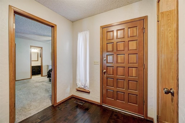 foyer featuring dark hardwood / wood-style flooring and a textured ceiling