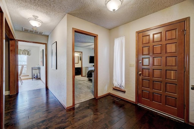 foyer featuring dark hardwood / wood-style floors and a textured ceiling